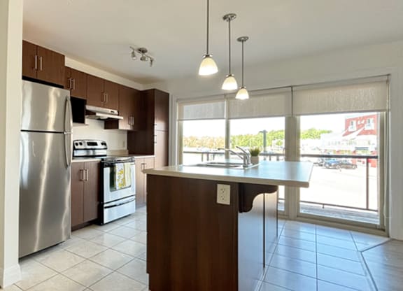 A kitchen with a refrigerator, stove, and oven.