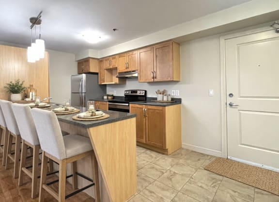A kitchen with wooden cabinets and a black countertop.
