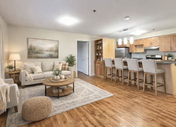 A well-lit, spacious kitchen and living room with wooden floors and furniture.