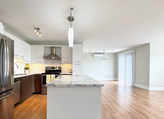 A modern kitchen with a marble island in the middle.