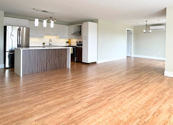 A kitchen with wooden floors and a refrigerator.