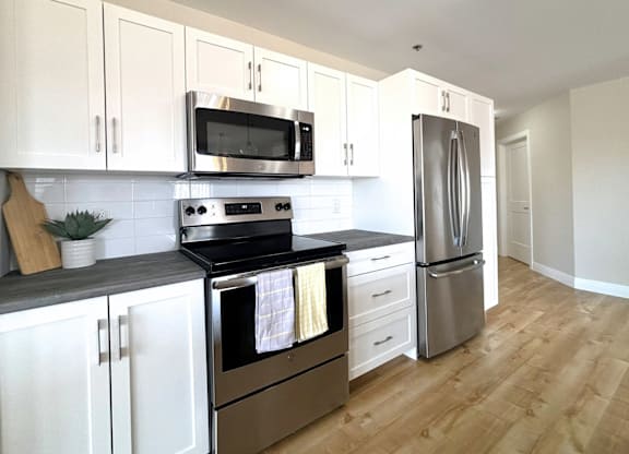 A kitchen with white cabinets and stainless steel appliances.