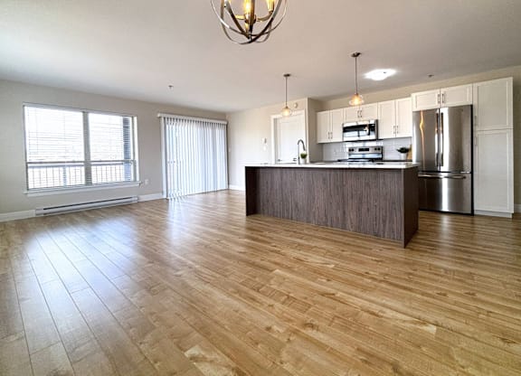 A kitchen with a wooden floor and a large island.