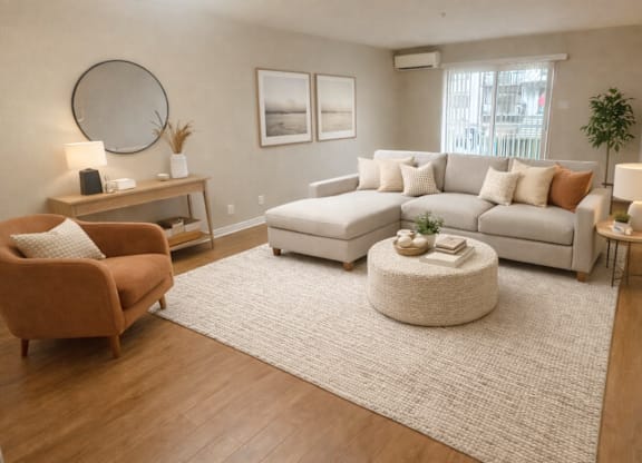 A living room with a brown armchair, a white sofa, and a round ottoman.