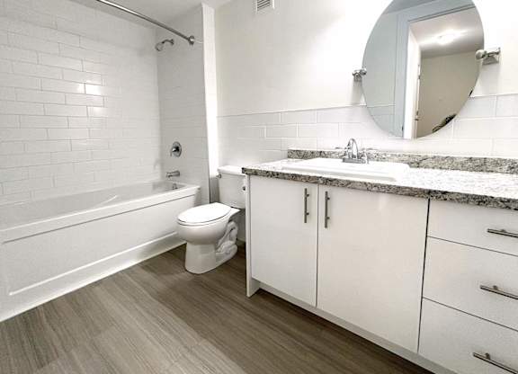 A white bathroom with a toilet, sink, and bathtub.