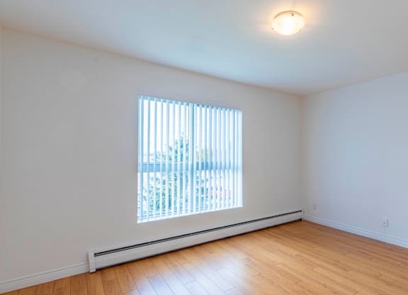 A room with a window and wooden floors.
