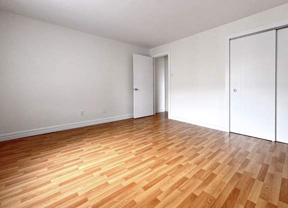A room with wooden flooring and white walls.