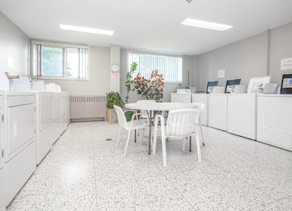 A white kitchen with a table and chairs.
