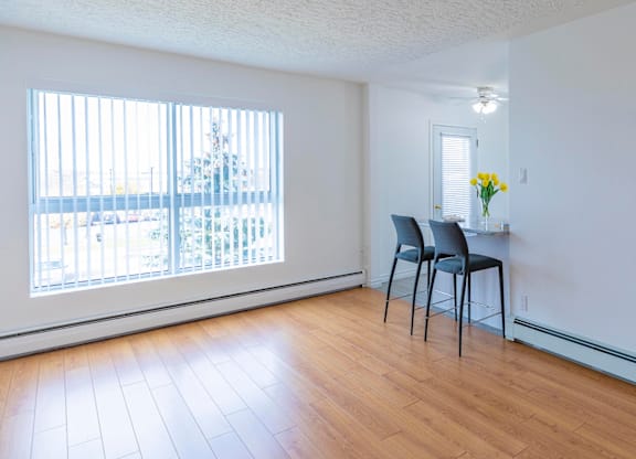 A room with a chair and a table with flowers on it.