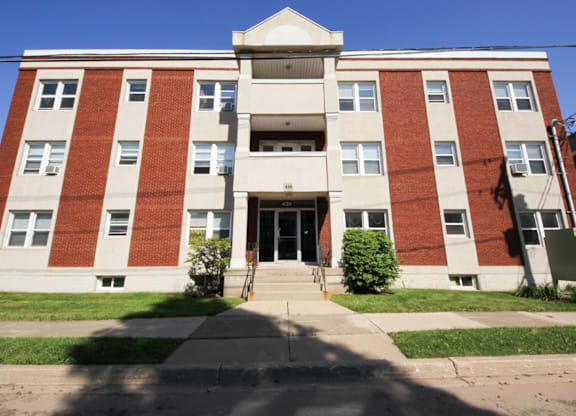 A red and white building with a black door and steps leading up to it.