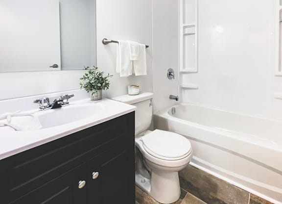 A white toilet sits next to a white sink in a bathroom.