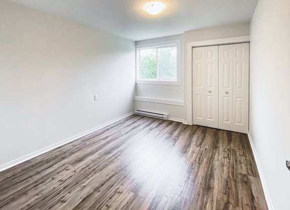 A room with wooden flooring and a white door.