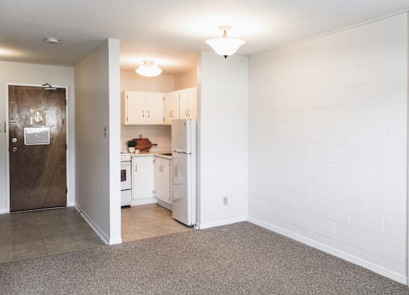 A kitchen with white cabinets and a brown door.