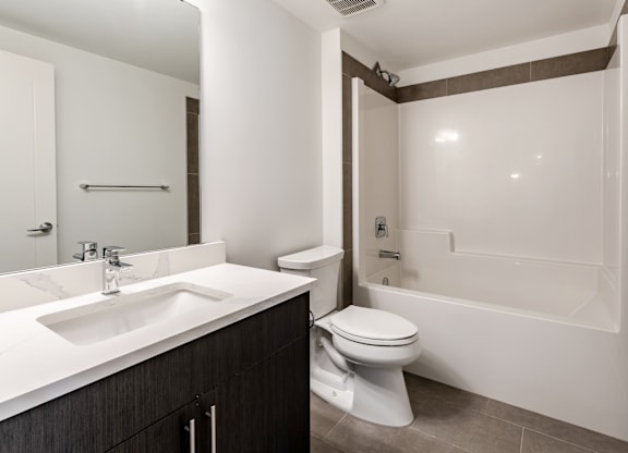 A modern bathroom with a white sink and toilet.