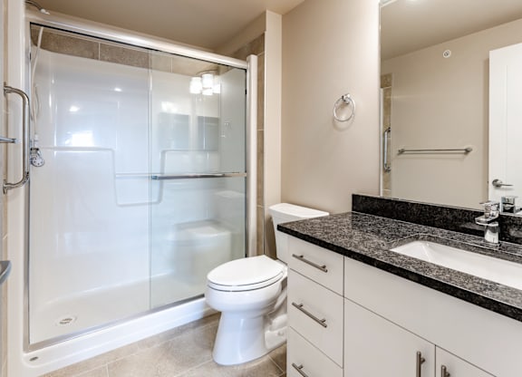 A bathroom with a toilet, sink, and shower.