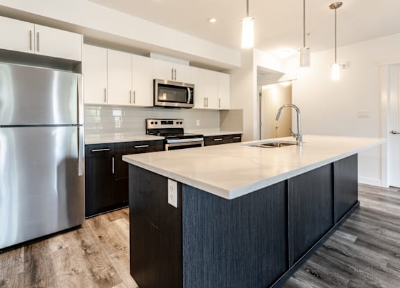 A modern kitchen with a large island and stainless steel appliances.