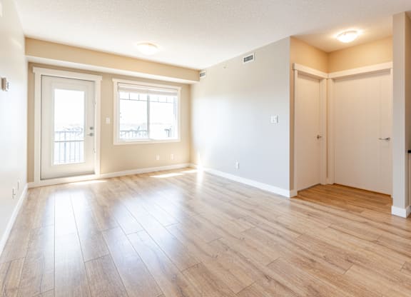 A room with wooden flooring and white walls.
