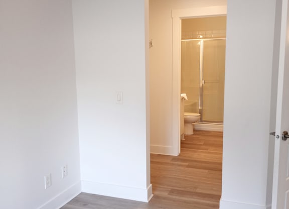 A white bathroom with a glass shower door.