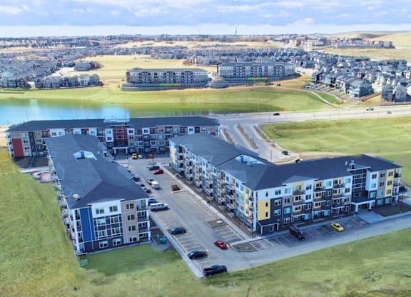 A large apartment complex with a parking lot in front.