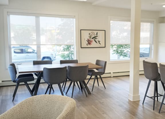 A room with a table and chairs and a painting on the wall.