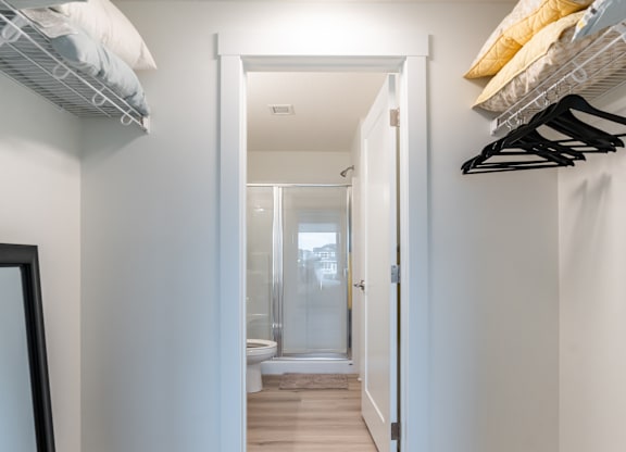 A hallway with a white door leading to a bathroom.