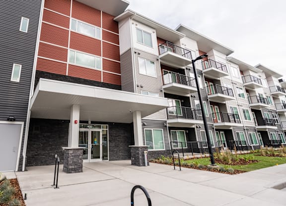 A modern apartment building with a red and grey facade.