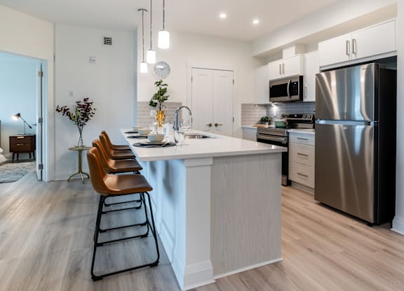 A modern kitchen with a large island and stainless steel appliances.