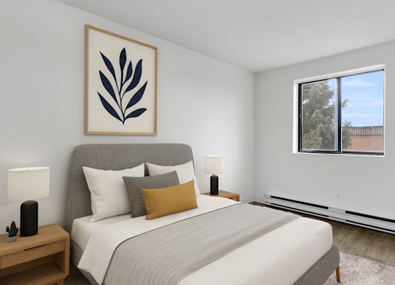 A bedroom with a large bed and a framed leaf picture on the wall.