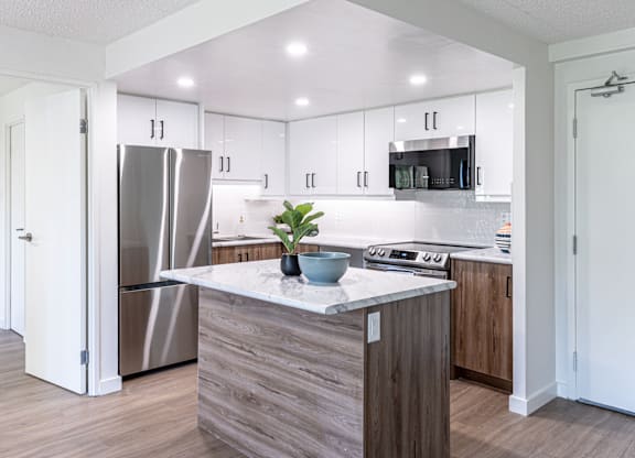 A modern kitchen with a wooden island and stainless steel appliances.