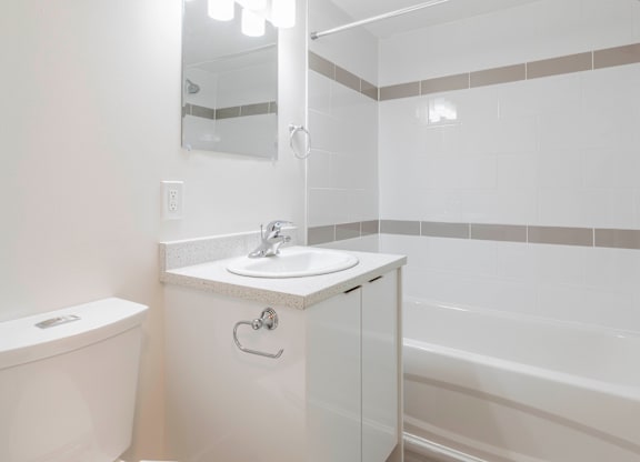 A white bathroom with a sink, toilet, and bathtub.