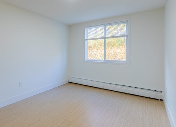 A room with a window and a light on the ceiling.
