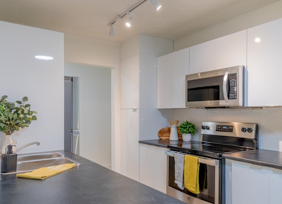 A modern kitchen with a stainless steel oven and microwave.