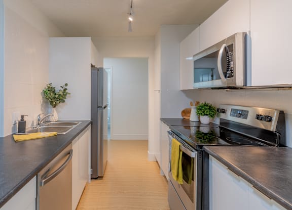 A modern kitchen with a stainless steel refrigerator, oven, and microwave.