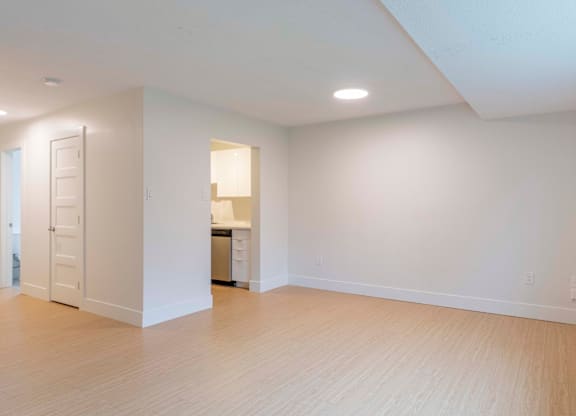 A large empty room with wooden floors and white walls.