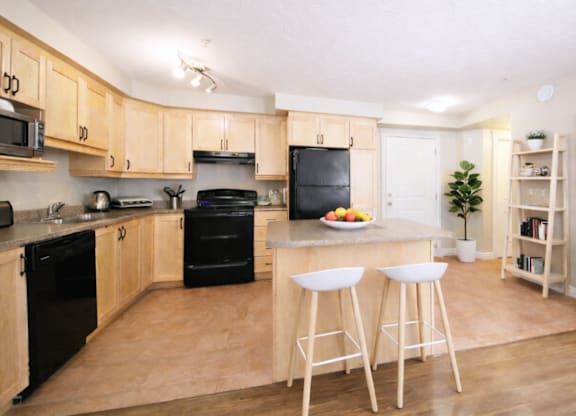 A kitchen with wooden cabinets and black appliances.