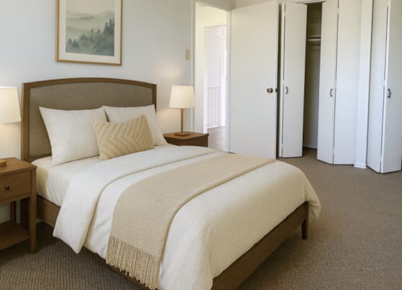 A bedroom with a large bed and a painting on the wall.