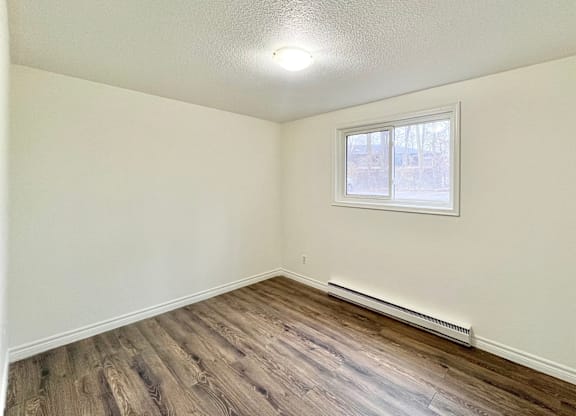 A room with a window and a radiator on the wall.
