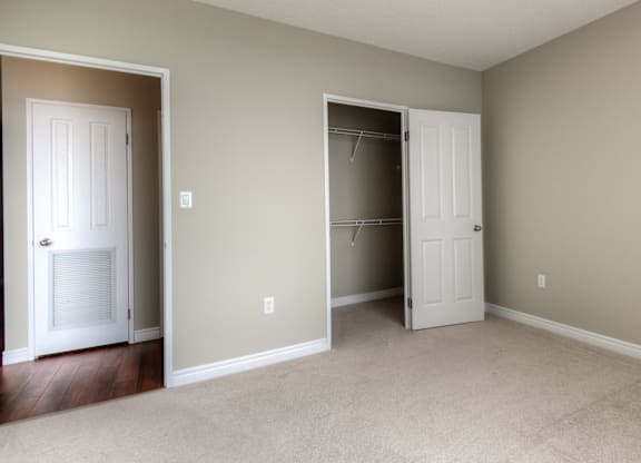 A room with two white doors and a carpeted floor.