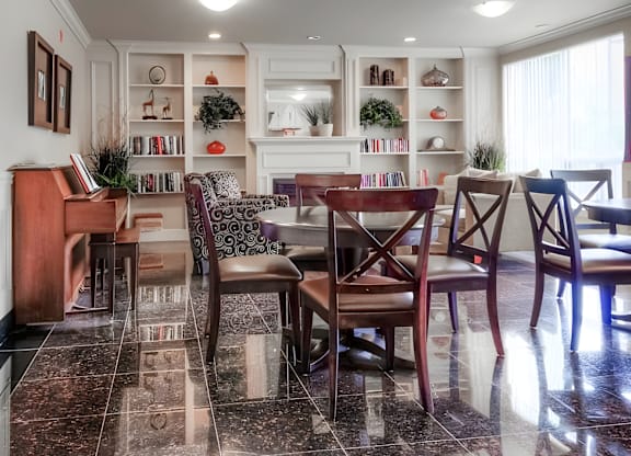 A dining room with a piano and a table set for four.