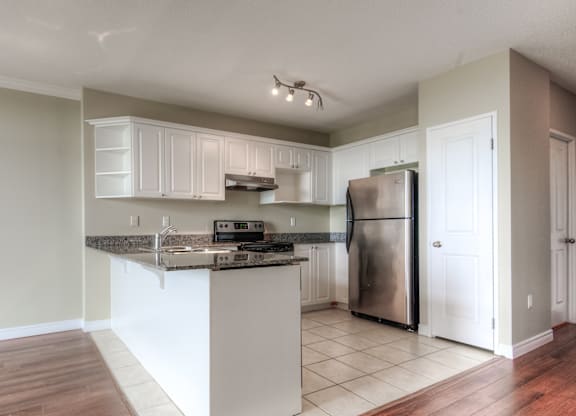 A kitchen with a white island and stainless steel appliances.