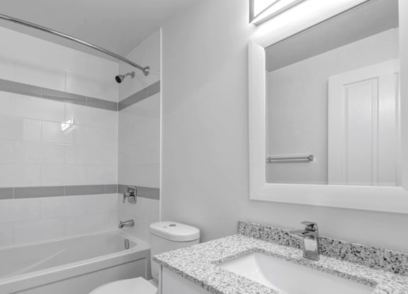A white bathroom with a toilet, sink, and shower.