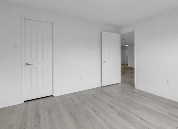 A room with a white door and a white wall.
