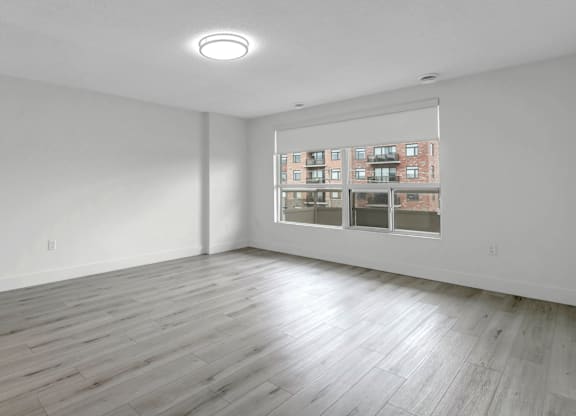 A room with a large window and wooden flooring.