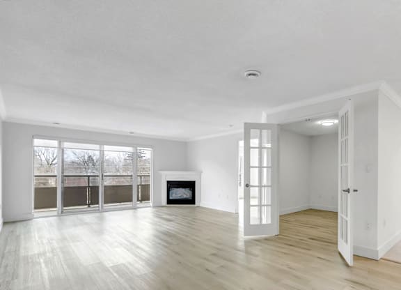 A spacious room with a fireplace and large windows.
