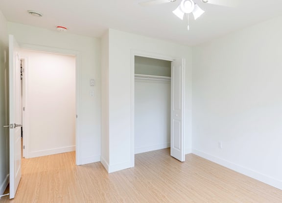 A room with a ceiling fan and light fixture.