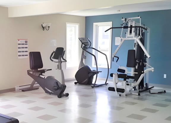 A gym with a variety of equipment including treadmills, stationary bikes, and weight machines.