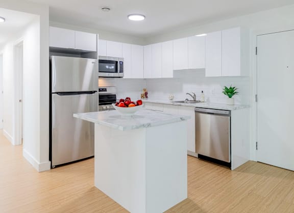 A modern kitchen with a white island in the middle.