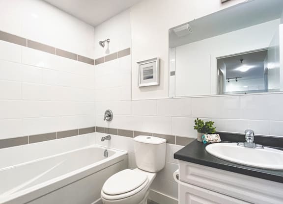 A white toilet sits next to a bathtub in a bathroom.