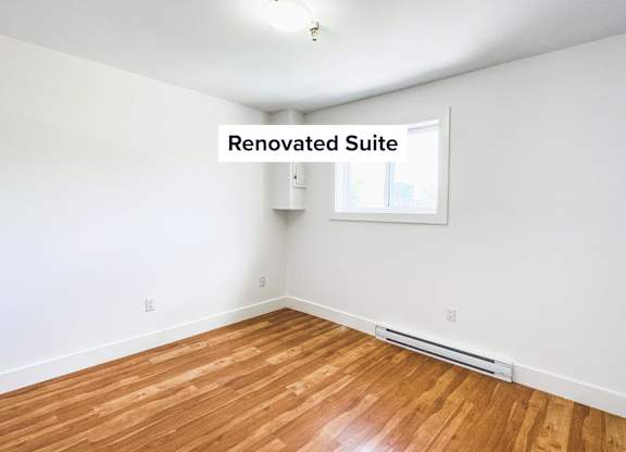 A renovated suite with wooden flooring and a window.