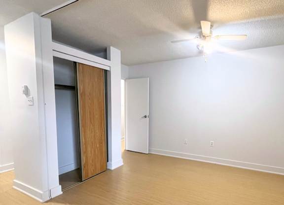 A room with a ceiling fan and a doorway leading to another room.